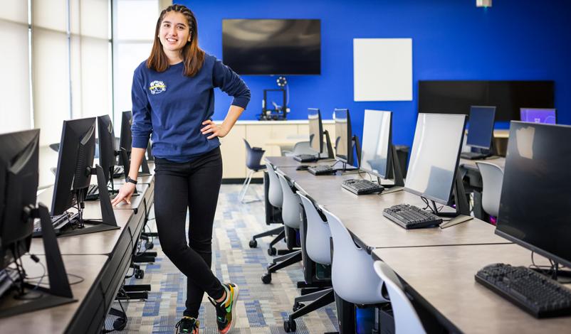 Nathalie Primbs '25 standing in the middle of Basile Hall's Data Science computer lab